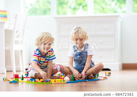 Kids play wooden railway. Child with toy train. 98472381