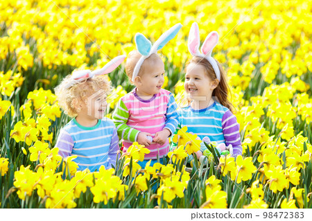 Kids with bunny ears on Easter egg hunt. 98472383