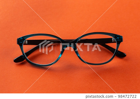 Stylish eyeglasses over orange background.  98472722