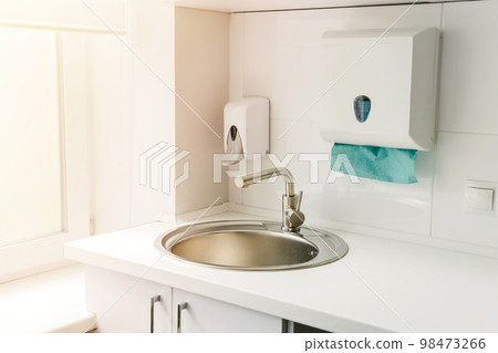Modern hospital ward, hand washing sink, liquid soap disinfector automatic dispenser, paper towels. 98473266