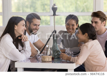 Multiracial group of happy cheerful young friends smoking hookah 98474116