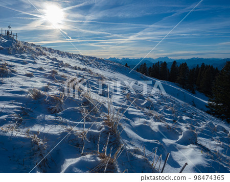 Lengries, Germany - December 28th 2022: A snow covered slope in the Bavarian Alps in the afternoon sunlight Lengries, Germany - December 28th 2022: A snow covered slope in the Bavarian Alps in the afternoon sunlight 98474365