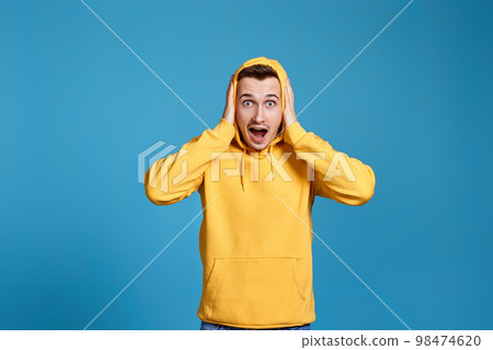 shocked man with round eyes, open mouth and hands 98474620
