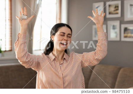 Purchase of real estate. Happy young caucasian woman realtor shows keychain and keyring. Concept of leasing, business and mortgage 98475510