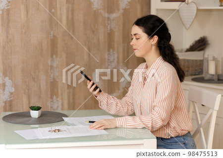 Purchase of real estate. Side view of woman realtor using cellphone. Concept of leasing, business and mortgage Purchase of real estate. Side view of woman realtor using cellphone. Concept of leasing, business and mortgage 98475513