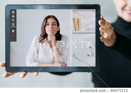Online coaching. Video chat. Business webinar. Virtual conference. Woman showing confident female expert at digital office on tablet screen. 98475572