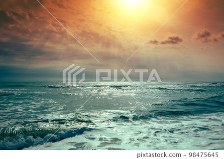 Seascape in the evening. Sunset over the sea with the beautiful dramatic blazing sky Seascape in the evening. Sunset over the sea with the beautiful dramatic blazing sky 98475645