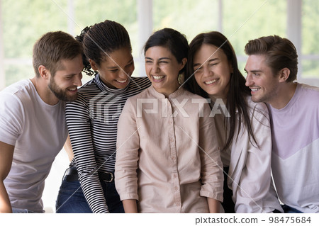 Excited cheerful multiethnic friends sitting close, chatting 98475684