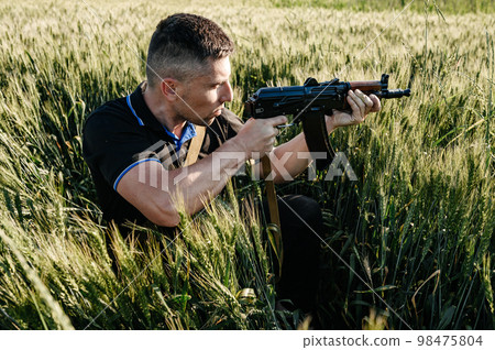 The man in the field with a machine gun, Ukrainian men prepare for the war. The man in the field with a machine gun, Ukrainian men prepare for the war. 98475804
