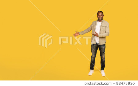 Cheerful middle aged african american male in casual showing hands on copy space, recommends ad and offer 98475950
