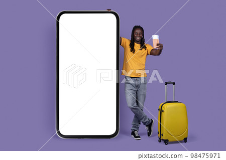 Happy african american guy traveller standing by smatphone, mockup 98475971