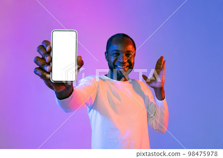 Happy black man showing smartphone and gesturing, mockup Happy black man showing smartphone and gesturing, mockup 98475978