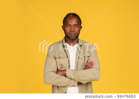 Serious confident middle aged african american male in casual crossed arms on chest, looking at camera Serious confident middle aged african american male in casual crossed arms on chest, looking at camera 98476063
