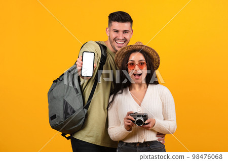 Happy surprised millennial arabic family with open mouth in glasses, backpack show phone with blank screen Happy surprised millennial arabic family with open mouth in glasses, backpack show phone with blank screen 98476068