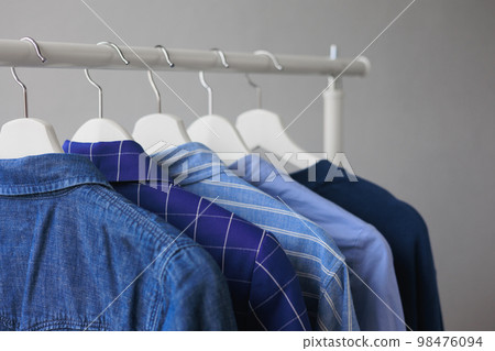 hangers with clothes, wardrobe shirt jacket blue. storing clothes or shopping. hangers with clothes, wardrobe shirt jacket blue. storing clothes or shopping. 98476094