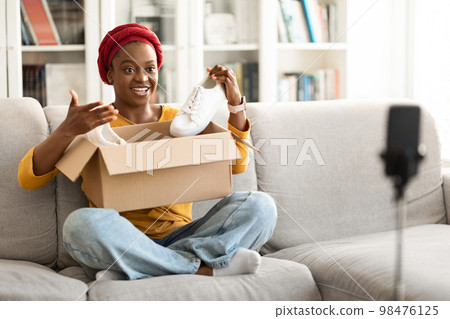 Social media influencer young black woman reviewing product new shoes 98476125
