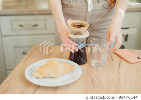 woman makes coffee in morning for breakfast, brew drip purover. americano cappuccino. woman makes coffee in morning for breakfast, brew drip purover. americano cappuccino. 98476144