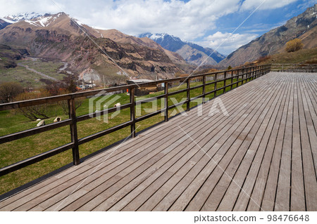 Empty wooden terrace with Stepantsminda landscape on a background Empty wooden terrace with Stepantsminda landscape on a background 98476648