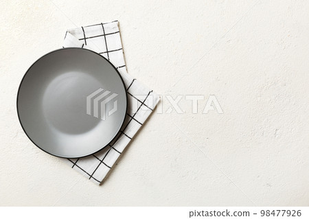 Top view on colored background empty round gray plate on tablecloth for food. Empty dish on napkin with space for your design 98477926