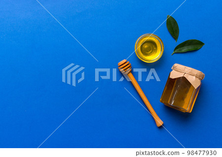 Honey jar with wooden honey dipper on white background top view with copy space. Delicious honey bottle 98477930