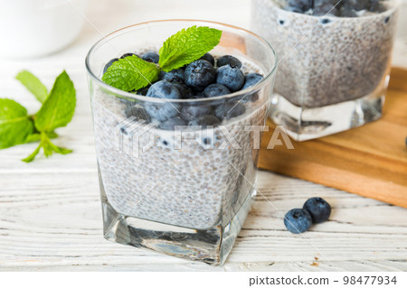 Healthy breakfast or morning with chia seeds vanilla pudding and blueberry berries on table background, vegetarian food, diet and health concept. Chia pudding with coconut milk and blueberry 98477934