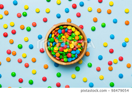 Multicolored candies in a bowl on a colored background. birthday and holiday concept. Top view with copy space Multicolored candies in a bowl on a colored background. birthday and holiday concept. Top view with copy space 98479054