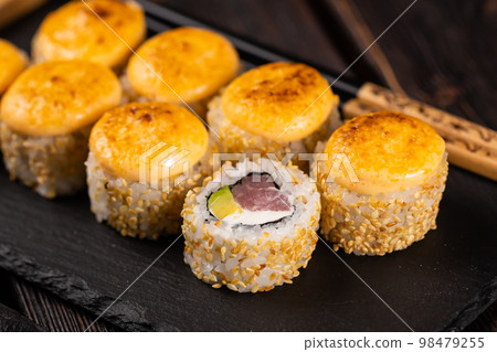 Sushi roll with tuna, avocado and tobiko caviar served on black board close-up - Japanese asian food 98479255