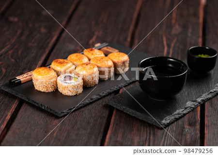 Sushi roll with tuna, avocado and tobiko caviar served on black board close-up - Japanese asian food 98479256
