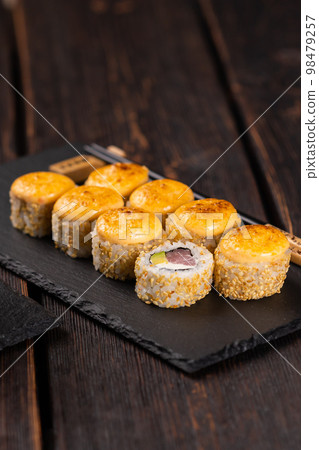 Sushi roll with tuna, avocado and tobiko caviar served on black board close-up - Japanese asian food 98479257