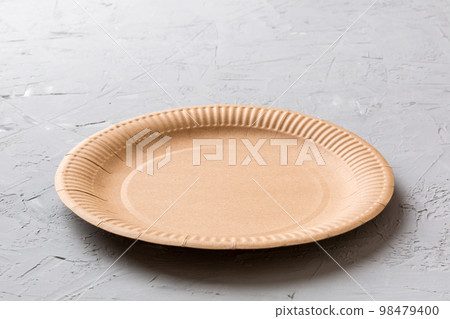 Perspective view of eco paper plate on cement background. Empty space for your design 98479400