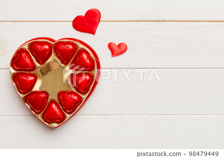 Delicious chocolate pralines in red box for Valentine's Day. Heart shaped box of chocolates top view with copy space 98479449