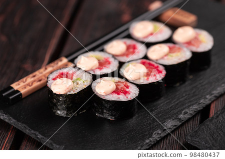 Maki sushi roll with salmon avocado and tobiko caviar served on black board close-up - Japanese food Maki sushi roll with salmon avocado and tobiko caviar served on black board close-up - Japanese food 98480437