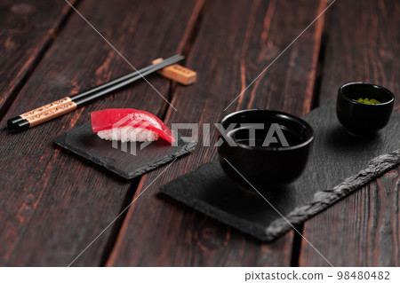 Delicious sushi maguro tuna. Nigiri with tuna on black and wooden background . Traditional Japanese cuisine Delicious sushi maguro tuna. Nigiri with tuna on black and wooden background . Traditional Japanese cuisine 98480482