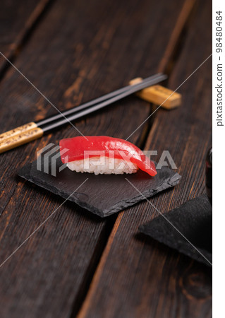 Delicious sushi maguro tuna. Nigiri with tuna on black and wooden background . Traditional Japanese cuisine Delicious sushi maguro tuna. Nigiri with tuna on black and wooden background . Traditional Japanese cuisine 98480484