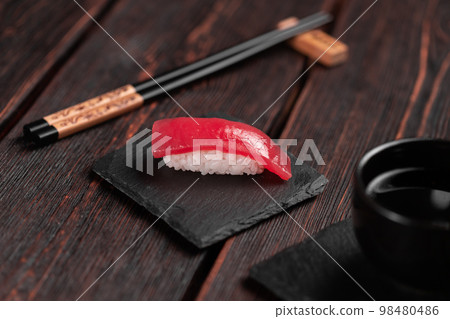 Delicious sushi maguro tuna. Nigiri with tuna on black and wooden background . Traditional Japanese cuisine Delicious sushi maguro tuna. Nigiri with tuna on black and wooden background . Traditional Japanese cuisine 98480486