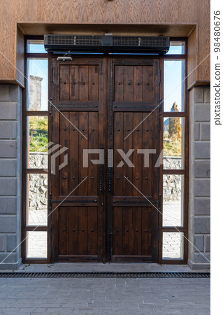 Old brown wooden textured wall between windows 98480676