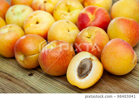 Fresh apricots whole and halves on wooden table 98483041