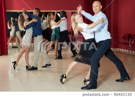 Positive adult couples dancing tango together in modern studio 98483130