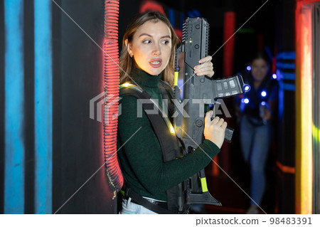 Young lady having fun playing lasertag in arena Young lady having fun playing lasertag in arena 98483391