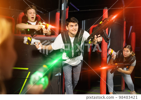 Three people having fun playing lasertag in arena 98483421