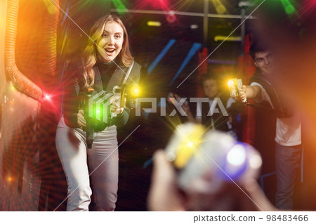 Young lady having fun playing lasertag in arena Young lady having fun playing lasertag in arena 98483466