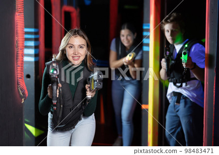 Young lady having fun playing lasertag in arena 98483471