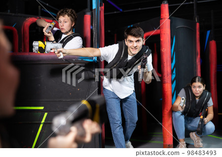 Three people having fun playing lasertag in arena Three people having fun playing lasertag in arena 98483493