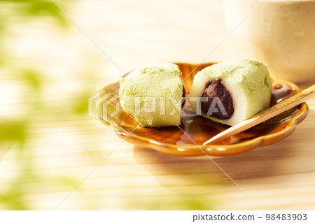 Uguisu rice cake with a wood grain background Uguisu rice cake with a wood grain background 98483903