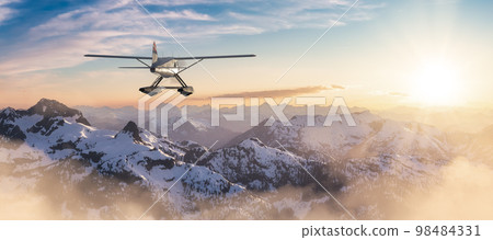 Seaplane flying over the Rocky Mountains during a colorful sunset. Seaplane flying over the Rocky Mountains during a colorful sunset. 98484331
