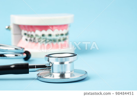 Medicine equipment stethoscope, metal wire dental braces on model teeth. Health dental care concept. 98484451