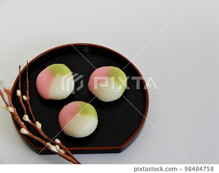 Three-color dumplings and branches with buds on a half-moon tray Three-color dumplings and branches with buds on a half-moon tray 98484758