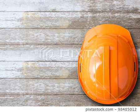 Top view with orange safety helmet on wood table background. 98485012