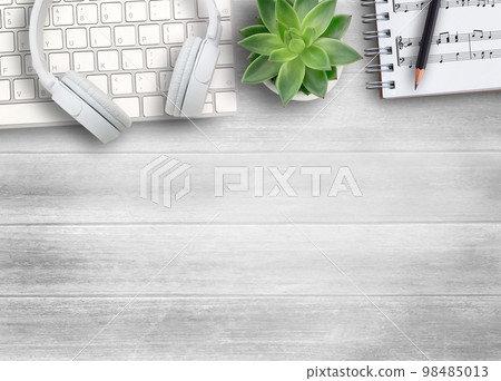 White head phone,keyboard  and sheet music on white wood table background. 98485013