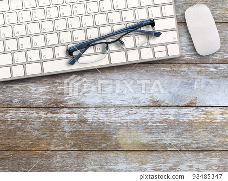 Top view with keyboard,mouse and glasses on wood table background. Top view with keyboard,mouse and glasses on wood table background. 98485347